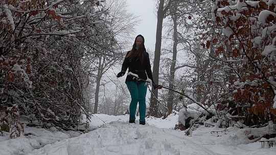 一个女人走在白雪覆盖的小径上