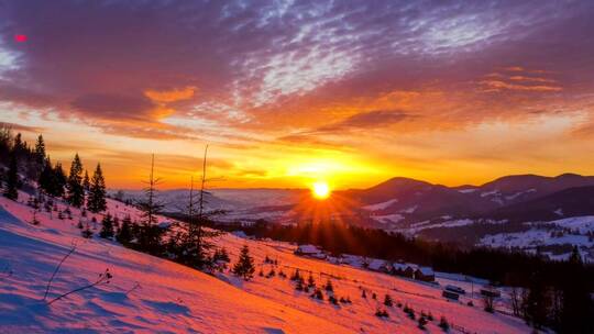 白雪皑皑的冬山上的日落