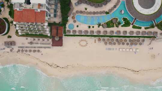 从空中俯瞰放松的海滩，水晶蓝色的游泳池，美丽的豪华水库温柔的海浪