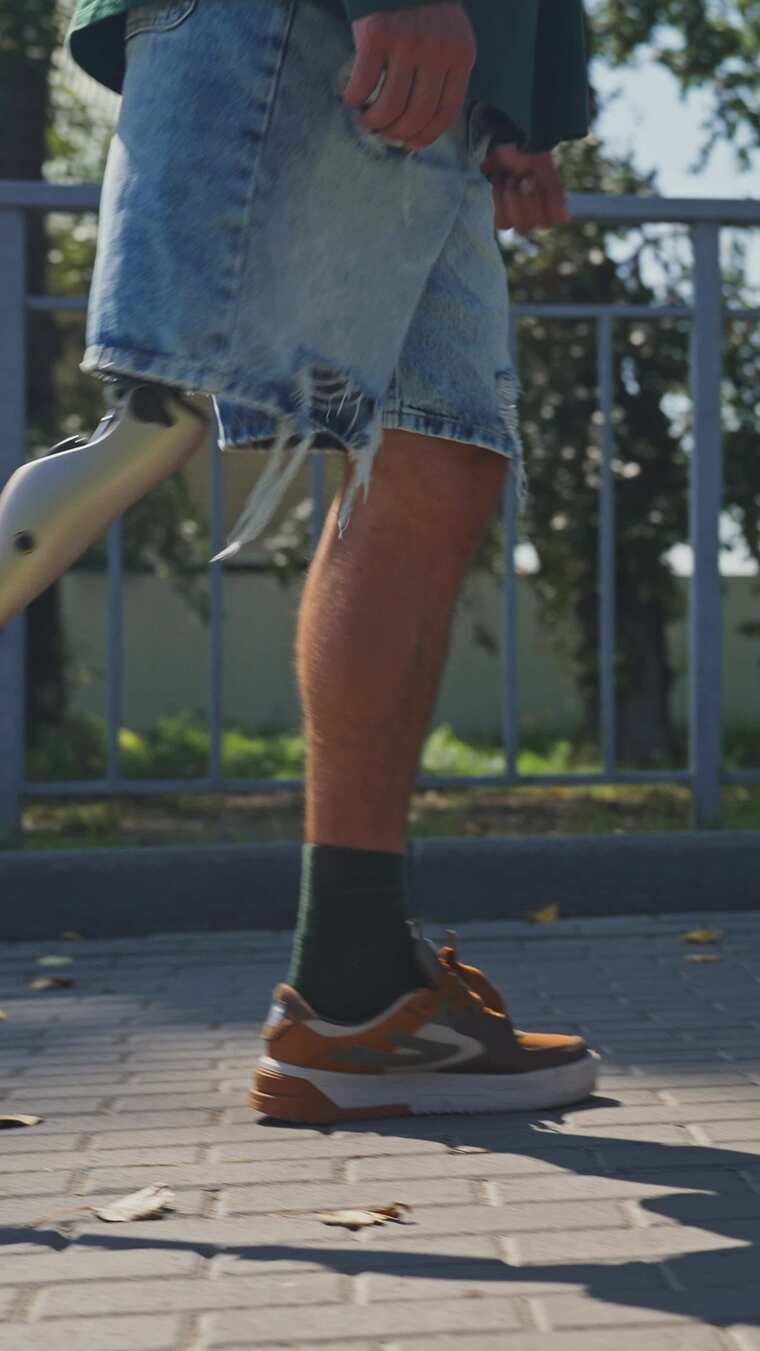 阳光明媚的下午，男人用假肢自信地走路