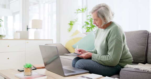 笔记本电脑、写作和财务文件与一位老妇人在