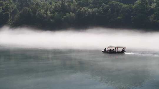 一只小木船正在雾漫东江上撒网捕鱼