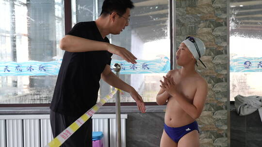 父亲在场边教导儿子如何游泳