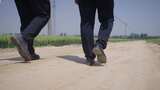 背影  脚步 公职人员走在田野的乡间小路上高清在线视频素材下载