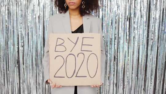 一个拿着标语牌说再见2020的女人的特写