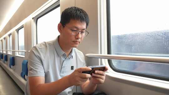 男子在卧铺火车过道上使用手机