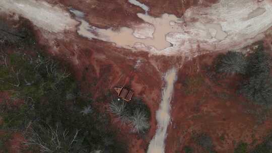 从高处俯瞰被红色肥沃土壤包围的生锈的旧采矿设备视频素材模板下载