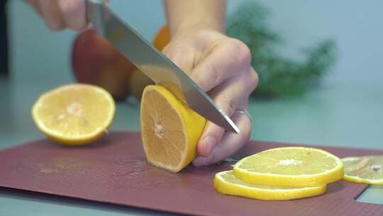 女孩把多汁的柠檬切成薄片。特写一个柠檬切视频素材模板下载
