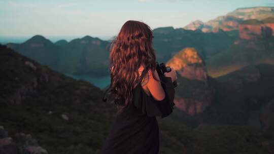 站在山顶的女人拿着望眼镜