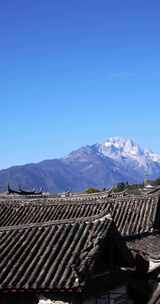 在丽江古城屋顶眺望远处的玉龙雪山竖屏