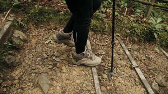 登山者手持登山杖下山脚部特写