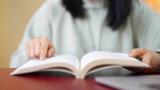 年轻女子图书馆在书架前翻看书本学习