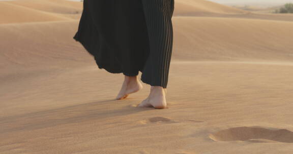 穆斯林女人赤脚在沙漠中行走