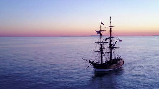 日落时分一艘高大帆船在海洋上航行