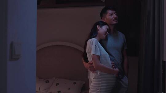 夜晚年轻夫妻幸福相拥陪伴安慰孕妇美好生活