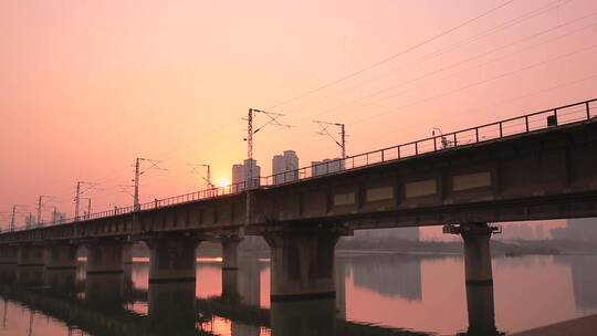 夕阳下在桥梁上行驰中的火车