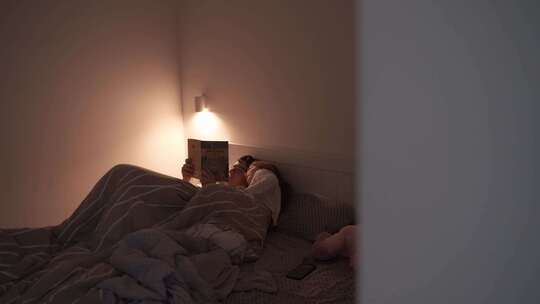 成人晚上和孩子在床上看书视频素材模板下载