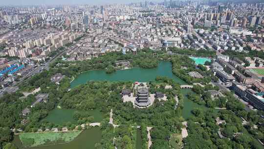 城市湖泊全景，周围环绕绿树与建筑