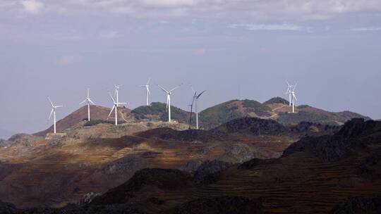 云南红土地丘陵上的风力发电大风车视频素材模板下载
