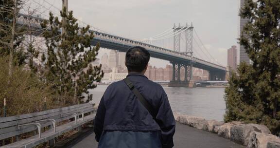 男人在曼哈顿桥下散步