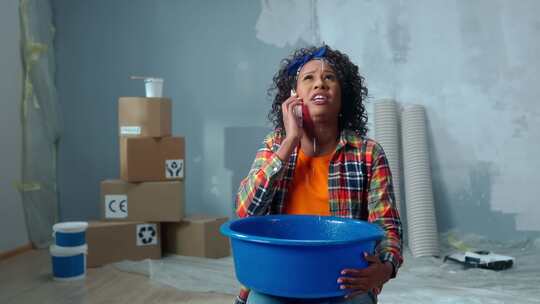 心烦意乱的非裔美国妇女拿着蓝色的碗，水滴从碗里滴下来
