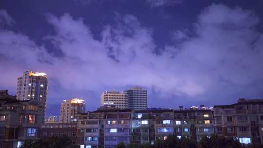 夏天台风天夜空中快速移动的云与城市老小区