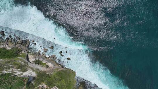 航拍印度尼西亚巴厘岛悬崖边下的绿松石大海