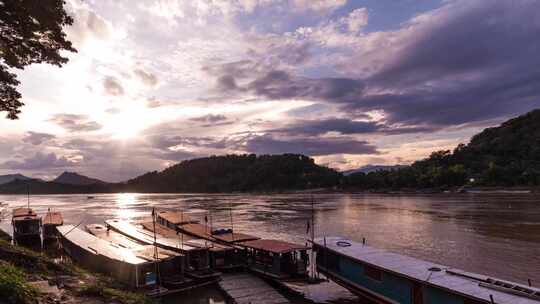 停泊在东南亚湄公河上的旅游船，伴着夕阳和云彩