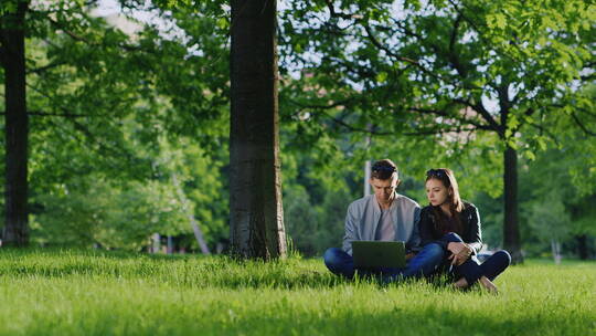 情侣在公园玩电脑