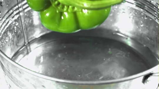 五颜六色的甜椒落在水下，用高速摄像机以1