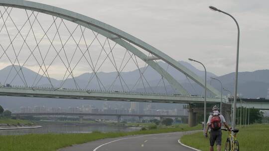 游客推着自行车经过天桥