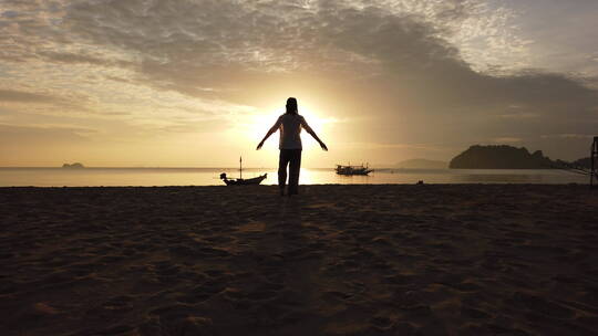 瑜伽大师在黄昏的海边沙滩做瑜伽