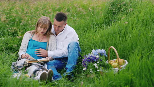 夫妇坐在草地上看书视频素材模板下载
