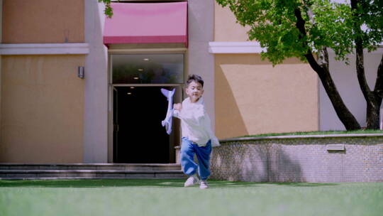 快乐的小男孩在草地上玩飞机视频素材模板下载