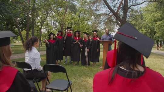 乐观的多元化多民族毕业生在毕业日庆祝大学