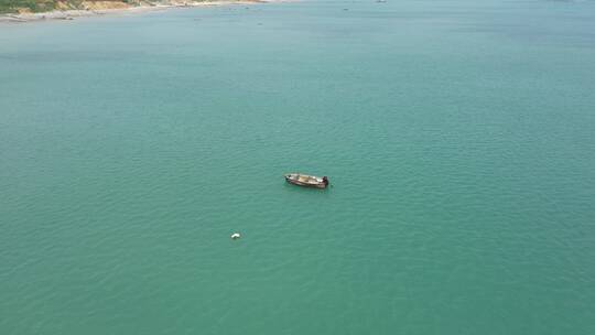 航拍淡蓝色海水中的小渔船