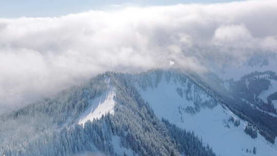 晴天覆盖冬季山脉的白云上方的电影天线视频素材模板下载