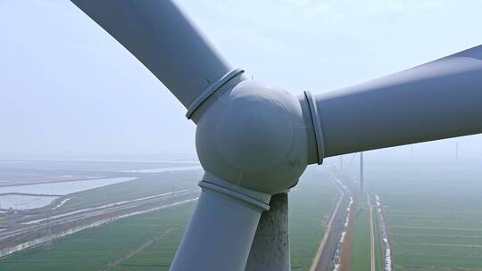 航拍高视角田地间的风力发电涡轮机特写