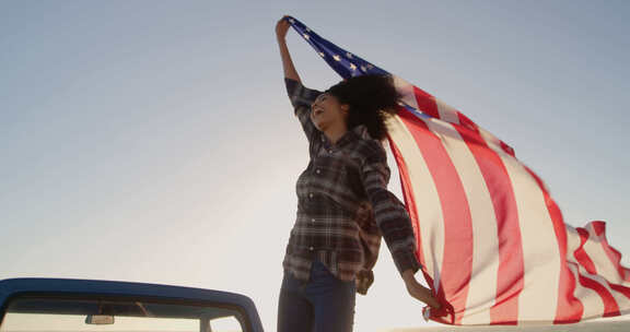 一名女子站在一辆皮卡上挥舞着美国国旗4k