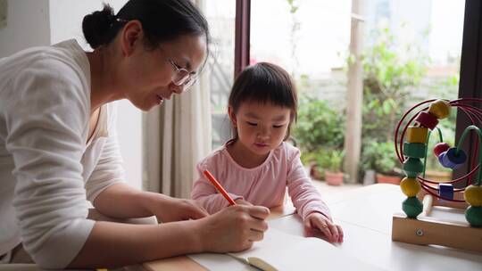 小女孩和妈妈在一起学习写字