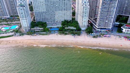 海滨城市高楼边的沙滩和海水景象