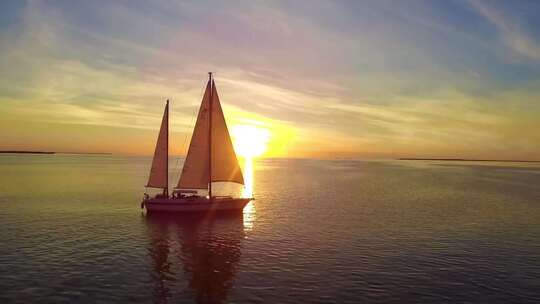 夕阳下大海中的帆船、一叶孤舟