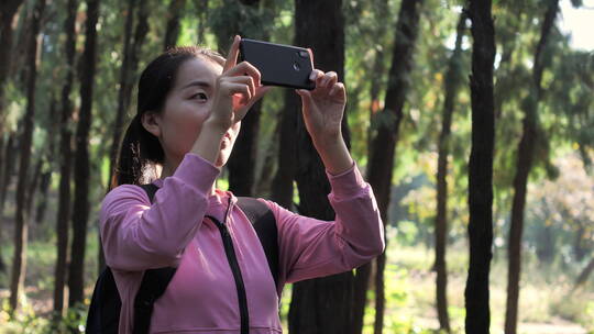 亚洲中国人女性森林树林旅游拿望远镜看风景