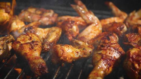 美味的鸡腿和鸡翅在烧烤架上被烤制