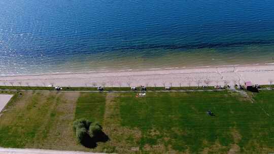 湖滩，人们日光浴和沐浴，花园和步行区。头顶无人机拍摄旅行视频素材模板下载