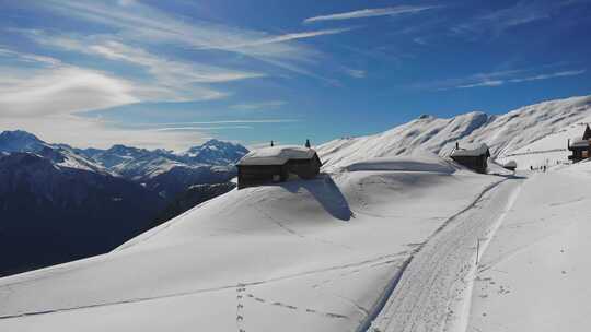 航拍坐落在高山上被大雪覆盖的村庄和道路