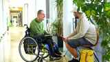 残疾男子在走廊与大学同事交谈高清在线视频素材下载