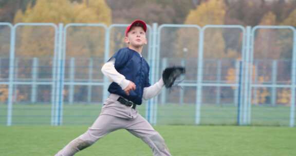 学校棒球锦标赛男孩投手奔跑并成功地在手套里接住了一个快球