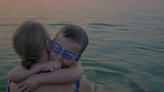 母亲和儿子在海里的拥抱和亲吻视频素材模板下载