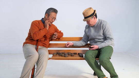 两位老年朋友坐在长椅上下象棋